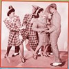 Two couples dancing in loud checker-patterned  1920s fashions.