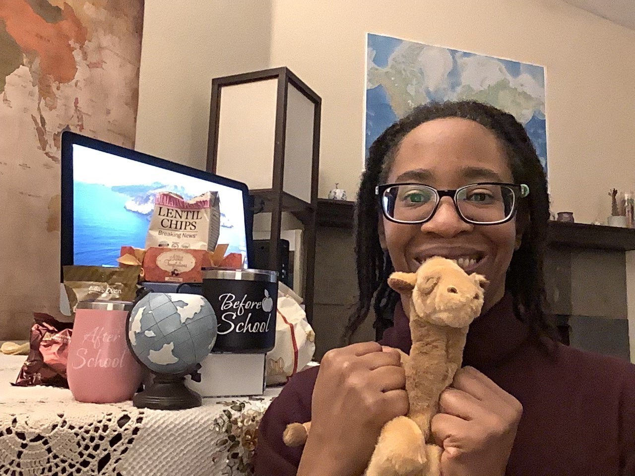Teacher at desk posing with camel plushie.