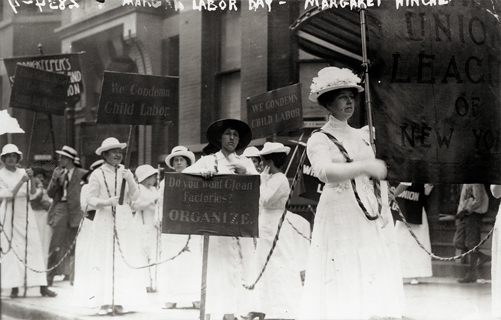 Suffragettes and members of the Laundry Workers Union of New York march in a Labor Day parade, demanding an end to child labor. 