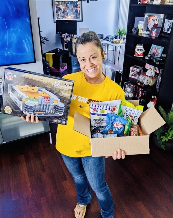 Teacher Rebecca Sloat poses with her prizes, a Heinz Field puzzle and a variety of snacks.
