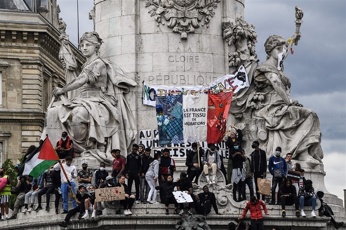 Protesters stand on the statue of Marianne on Place de la Republique in Paris on June 13, 2020